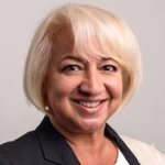 Professional headshot of a smiling woman with short blonde hair.