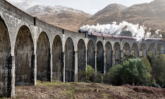 A viaduct in scotland with a steam train