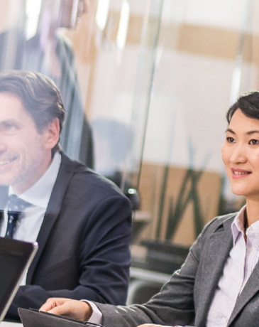 Business professionals in suits discussing strategy during a formal meeting.