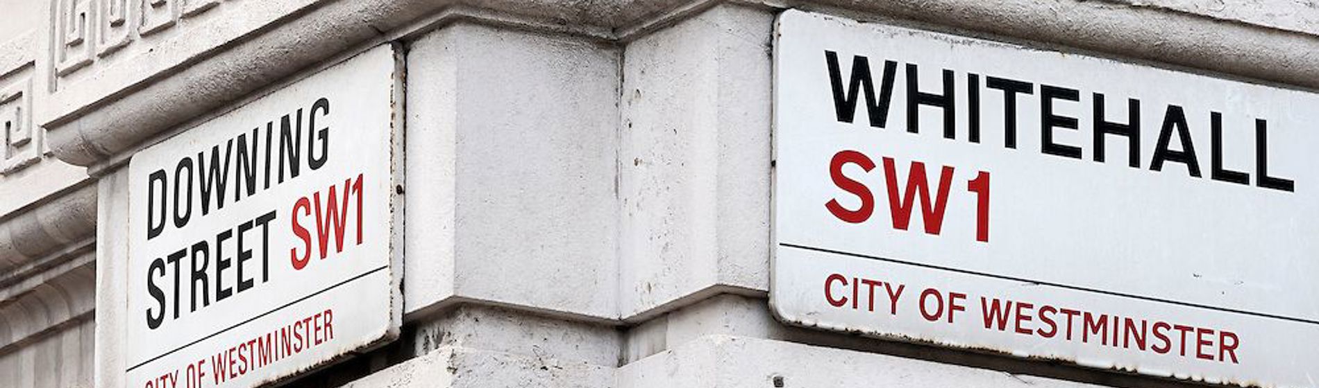 Corner view of London street signs for Whitehall and Downing Street, SW1.
