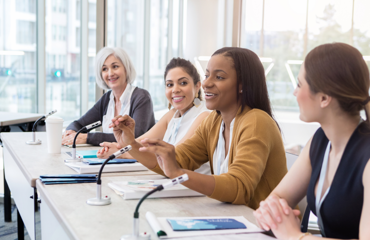 A group of female professionals talking at a panel