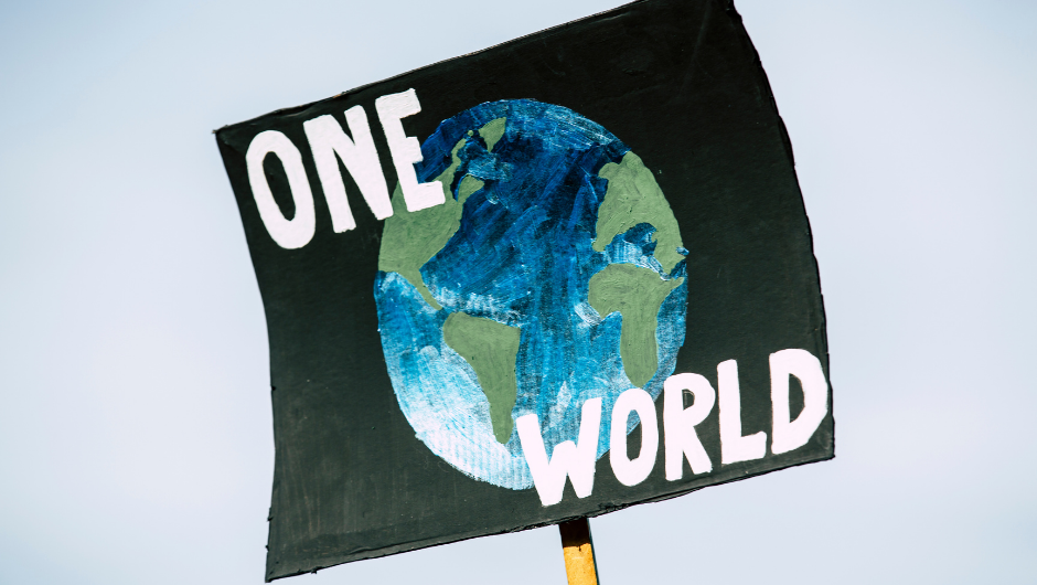 A placard from a climate change rally, stating 'One World'