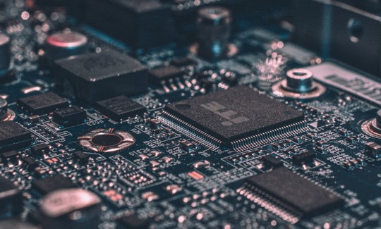 Detailed view of a computer circuit board, showing microchips and connections.
